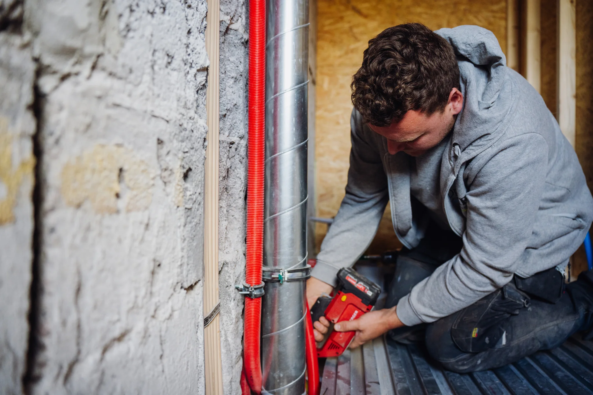 installatie monteur werkt aan het plaatsen van verschillende leidingen zoals waterleiding, gasleiding en afvoer