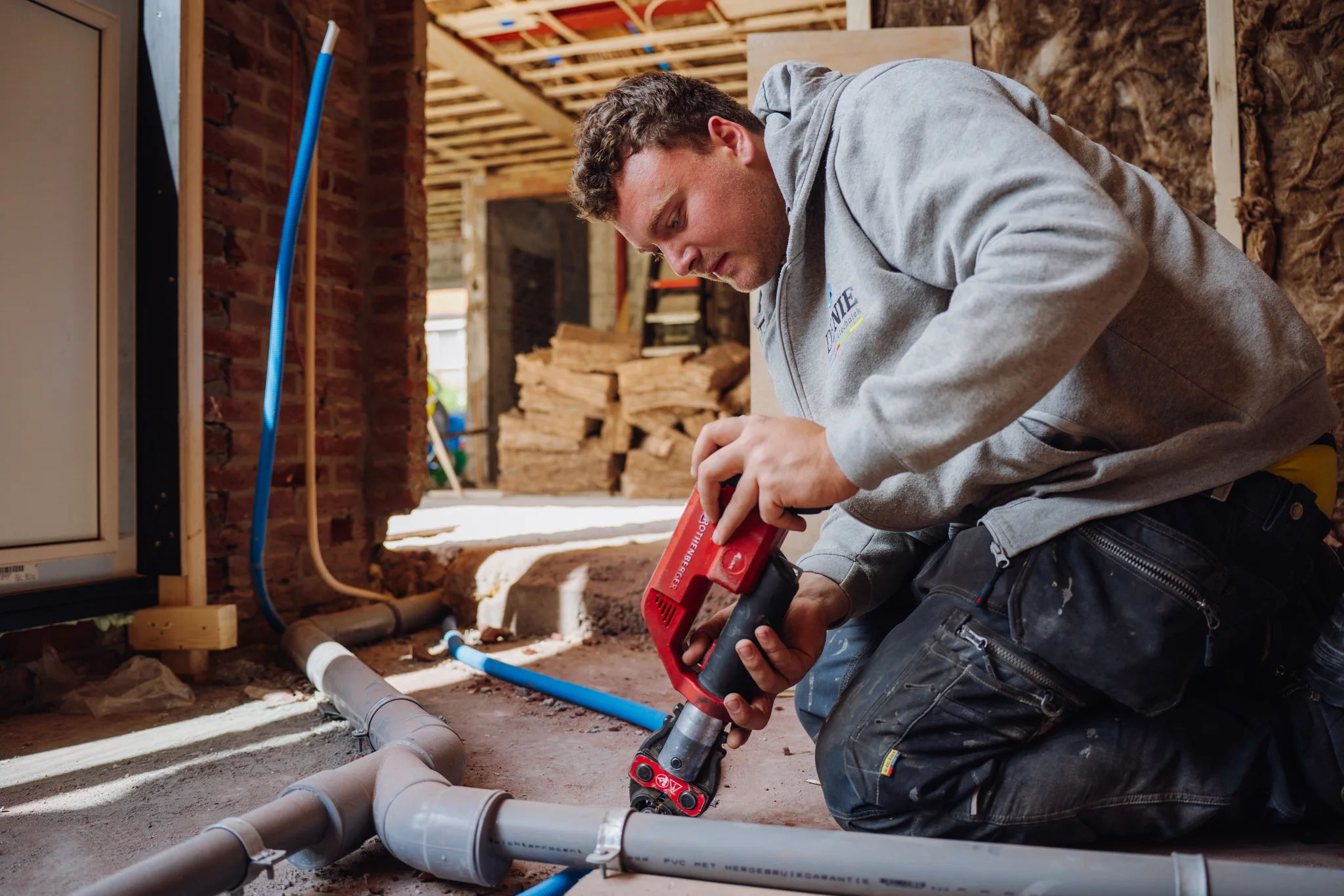 installatiemonteur werkt aan diverse leidingwerk in een nieuwbouwlocatie